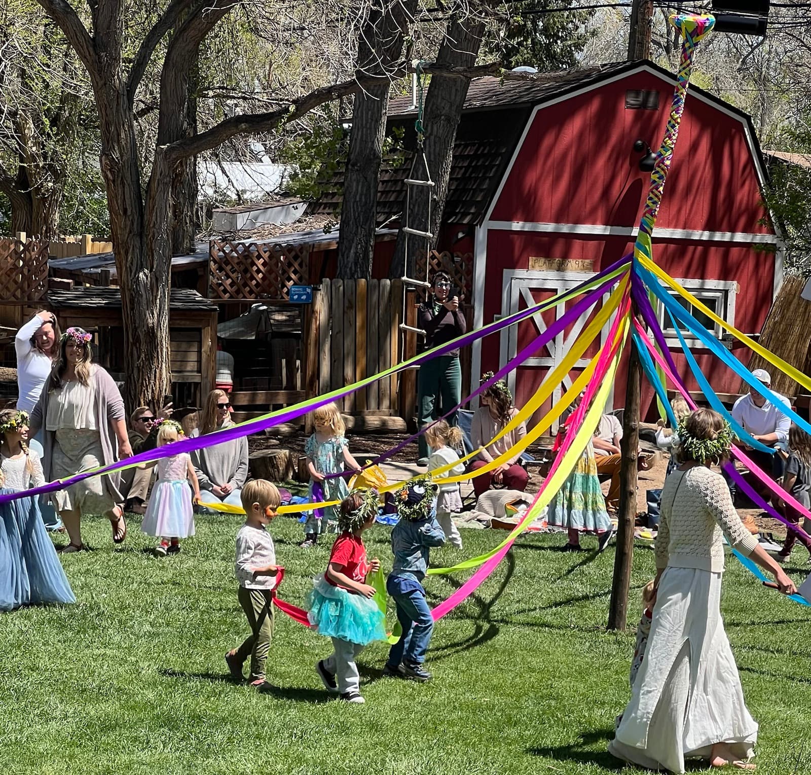 Children in flower crowns dancing round the maypole